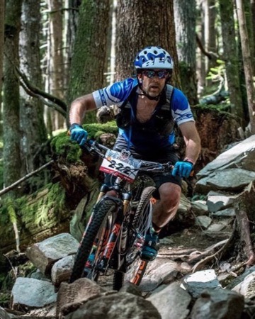 Errol Denger riding a mountain bike down a rocky forest trail